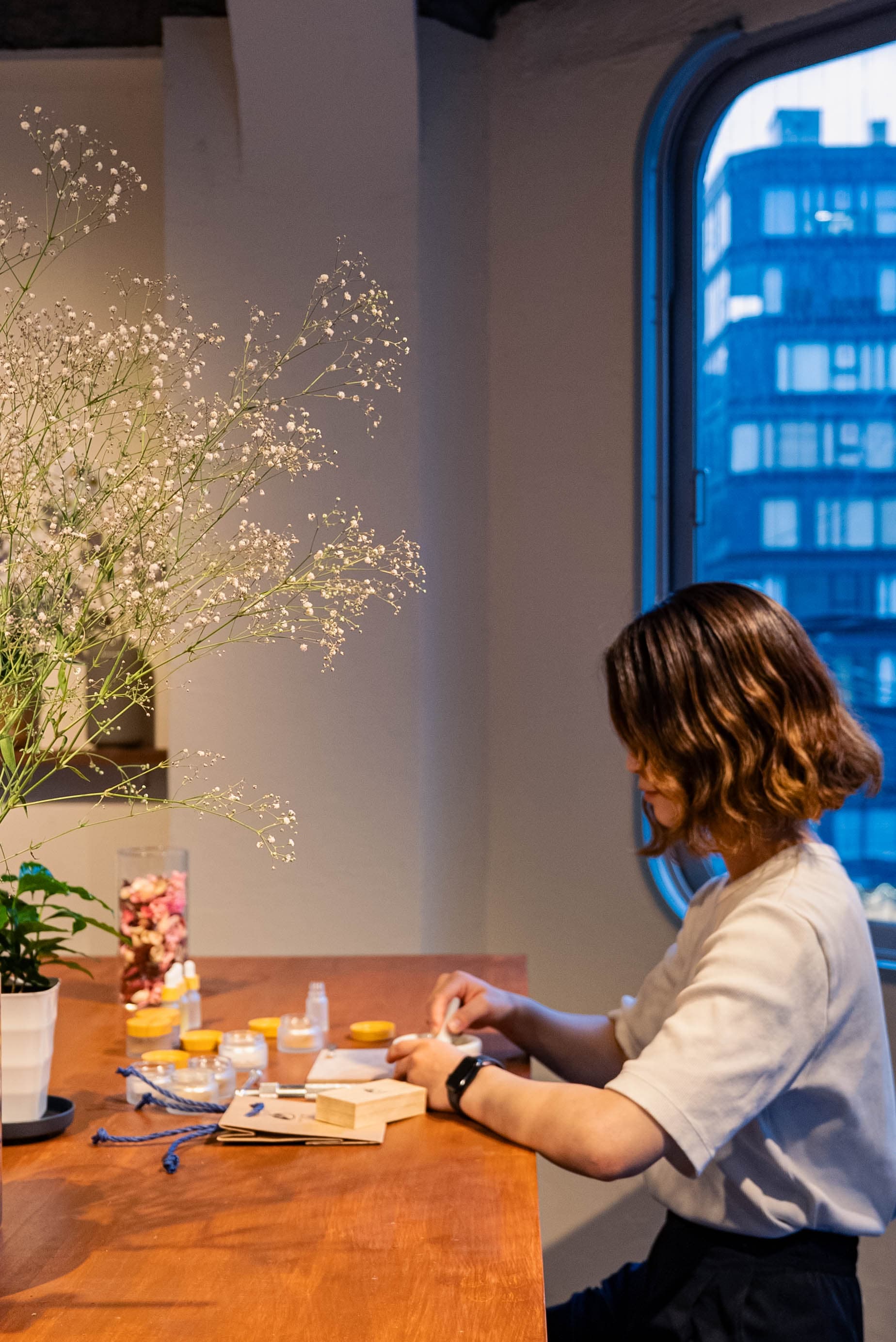 A guest blending incense at the window-side table at TSUTSUMU