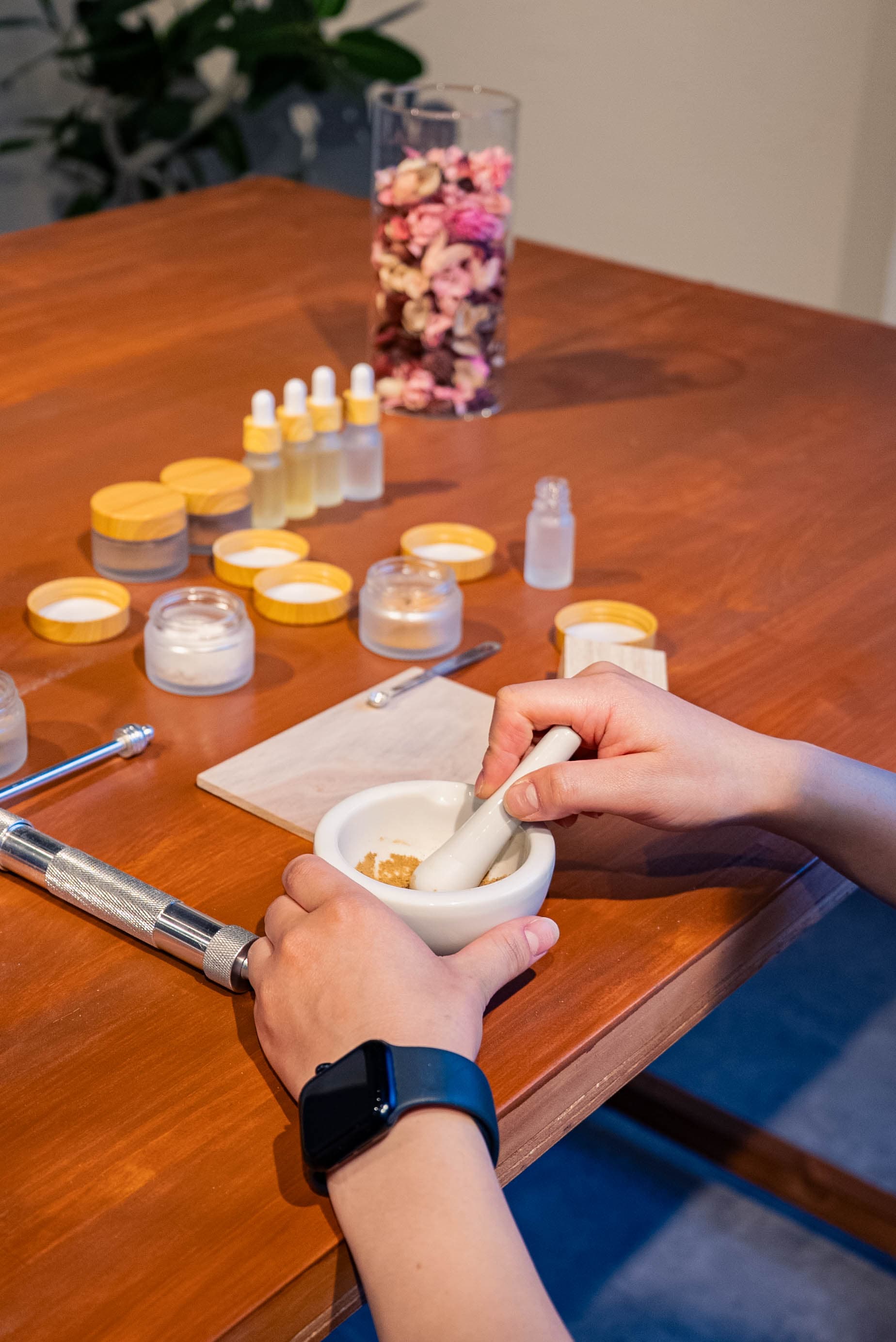 Hands blending incense ingredients with a mortar and pestle