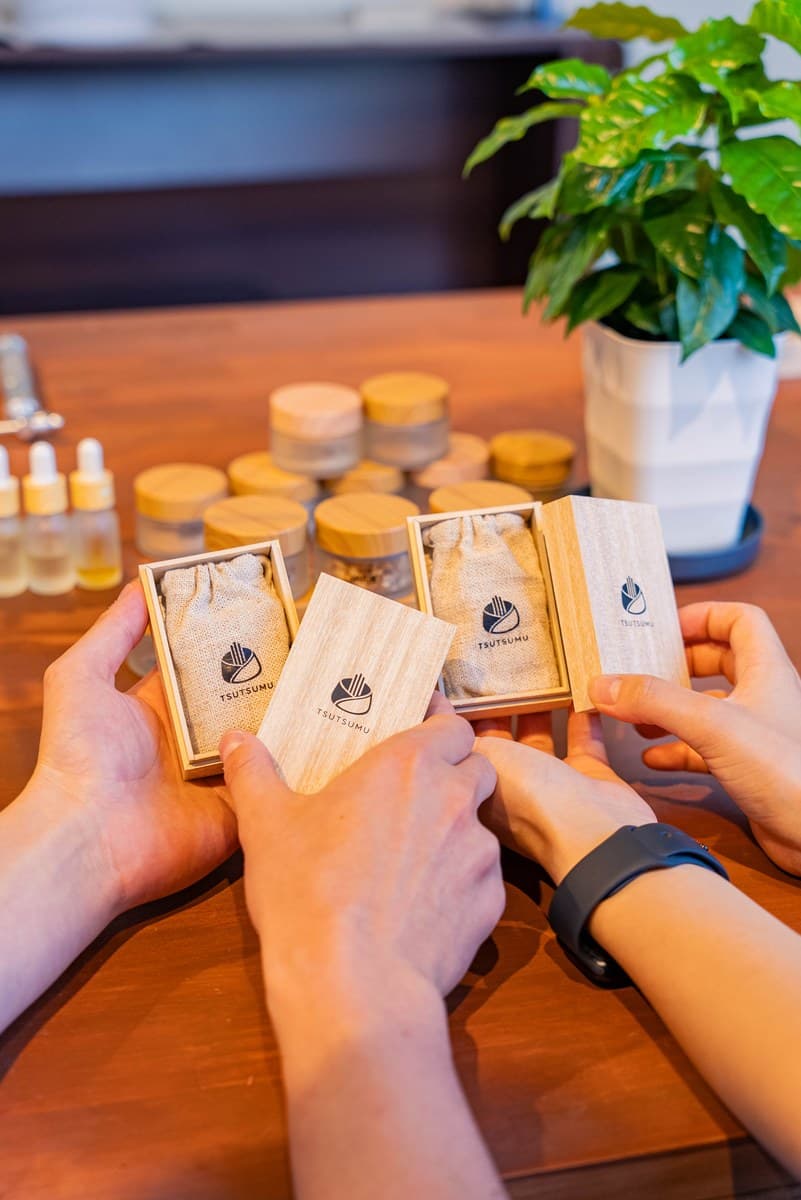 Two people each holding their own wooden box