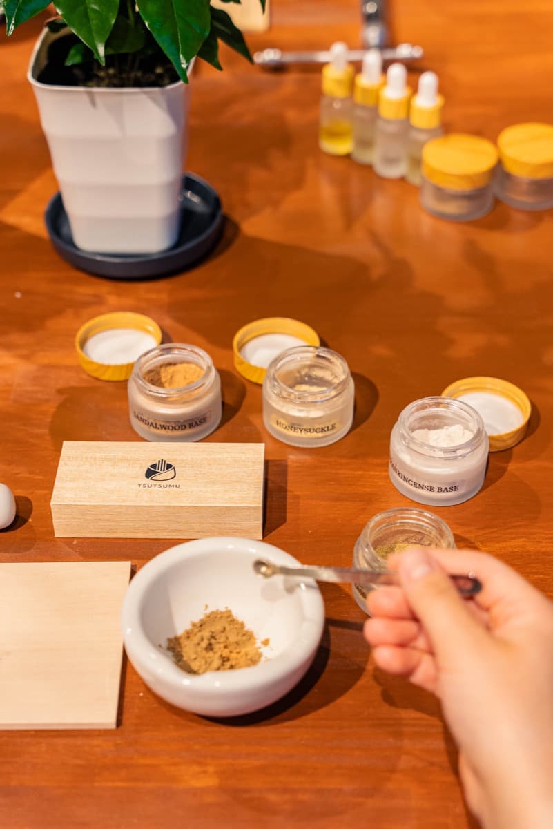 A guest's hands choosing and blending fragrances